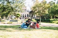 a man and a child sitting on the grass at Stayokay Hostel Amsterdam Vondelpark in Amsterdam