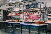 a bakery with two tables with food on it at Stayokay Hostel Amsterdam Vondelpark in Amsterdam