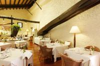 una sala da pranzo con tavoli e sedie bianchi di L’Hermitage Hotel & Spa a Orient