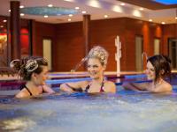 three women are swimming in a swimming pool at Hotel Vitality in Vendryně