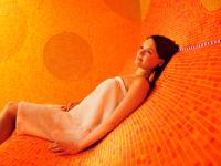 a woman in a white dress laying on a bed at Hotel Vitality in Vendryně
