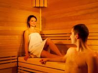 a man and a woman sitting in a sauna at Hotel Vitality in Vendryně