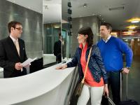 two men and a woman standing at a counter at Hotel Vitality in Vendryně