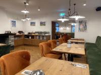 Un restaurante con mesas y sillas de madera y un mostrador. en Hotel Radetzky, en Sankt Gilgen