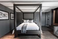 a bedroom with a canopy bed with white sheets at MAISON de la Bonne Vie in Thérondels