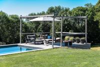 a patio with a pool and an umbrella and a dog at MAISON de la Bonne Vie in Thérondels