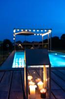 a table with candles next to a swimming pool at MAISON de la Bonne Vie in Thérondels
