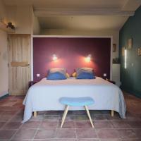 a bedroom with a large bed and a blue stool at chambre d&#39;hôtes Et Puis Voilà! in Murs