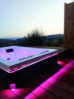 a bath tub with pink lights on a deck at chambre d&#39;hôtes Et Puis Voilà! in Murs