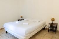 a bedroom with a white bed with two night stands at Cacatoès in Saint-Aignan