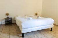 a bedroom with a white bed with two towels on it at Cacatoès in Saint-Aignan