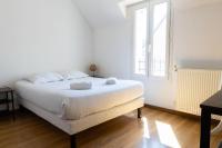 a white bed in a room with a window at Cacatoès in Saint-Aignan