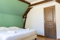 a bedroom with a white bed and a wooden door at Cacatoès in Saint-Aignan