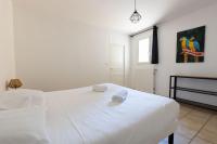 a white bedroom with a white bed and a window at Cacatoès in Saint-Aignan