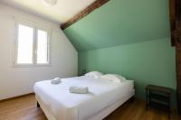 a bedroom with a large white bed with a window at Cacatoès in Saint-Aignan