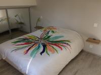 a bed with a painting of a flower on it at Villa les Chardons in La Baule-les-Pins