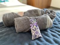 a stuffed animal on a bed with a purple bow at LES ROCHES DE BAUDISSET in Saint-Paul-en-Forêt