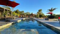 a pool at a resort with a red umbrella at LES ROCHES DE BAUDISSET in Saint-Paul-en-Forêt