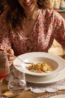 una donna seduta a un tavolo con un piatto di cibo di Masseria San Paolo Grande a Ostuni