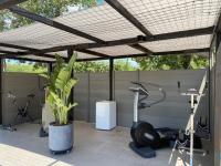 a fitness center with exercise equipment under a pergola at LES ROCHES DE BAUDISSET in Saint-Paul-en-Forêt