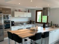 a kitchen with a wooden table and black chairs at Appartement spacieux et lumineux in Sélestat