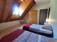 a bedroom with two beds and a window with a roof at Auberge du Freney in Le Freney-dʼOisans