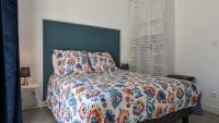 a bedroom with a bed with a colorful comforter at Le petit Moulin de la Motte in Bellenot-sous-Pouilly