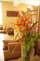 a glass vase filled with flowers on a table at Hotel Maharajah in Mamoudzou