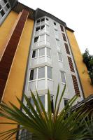 a tall building with white windows next to a plant at Hotel Maharajah in Mamoudzou