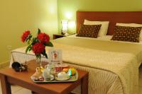 a hotel room with a bed and a table with a tray of food at Hotel Maharajah in Mamoudzou