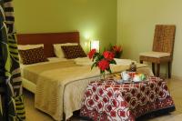 a hotel room with a bed and a table with flowers on it at Hotel Maharajah in Mamoudzou