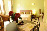 a room with a bed and a table with flowers on it at Hotel Maharajah in Mamoudzou
