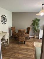 a dining room with a table and chairs and a clock at Résidence Océane Appartement Nature in Albi