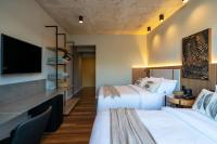 two beds in a hotel room with a flat screen tv at Jangal das Araucárias Swan Design Hotel Canela in Canela