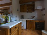 a kitchen with wooden cabinets and a white counter top at Maison Le Palais, 4 pièces, 6 personnes - FR-1-418-116 in Le Palais
