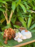 ein Teller mit Fleisch und Reis auf einem Blatt in der Unterkunft S Resorts Hidden Valley Bali in Uluwatu