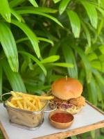 ein Hähnchensandwich und Pommes frites auf einem Tisch in der Unterkunft S Resorts Hidden Valley Bali in Uluwatu