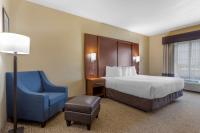 Una habitación de hotel con una cama y una silla azul. en Best Western Texas City, en Texas City