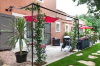 a patio with a red umbrella and some plants at La Casa dei Sogni in Flayosc