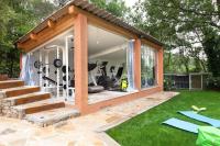 a gym with glass doors and a green yard at La Casa dei Sogni in Flayosc