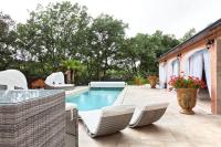 a backyard with a swimming pool with chairs and a table at La Casa dei Sogni in Flayosc
