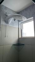 a bathroom with a shower with a window at Residencial Havaí in João Pessoa