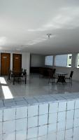 a room with tables and chairs in a building at Residencial Havaí in João Pessoa