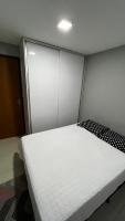 a white bed in a room with a door at Residencial Havaí in João Pessoa