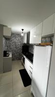 a kitchen with white cabinets and a refrigerator at Residencial Havaí in João Pessoa