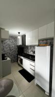 a kitchen with white cabinets and a white refrigerator at Residencial Havaí in João Pessoa