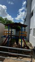 two chairs and a picnic table in front of a building at Residencial Havaí in João Pessoa