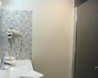 a bathroom with a shower and a sink at Hôtel Arcadia in Lannion