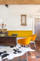 a living room with yellow chairs and a table at B&amp;B Leonie in Alveringem