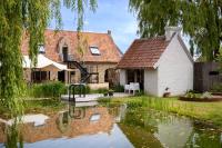 a house with a pond in the yard at B&amp;B Leonie in Alveringem